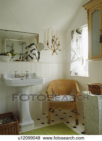 Wicker Chair Below Window In Small White Cottage Bathroom With Pedestal Basin And Panelling To Dado Height Stock Photo U12099048 Fotosearch