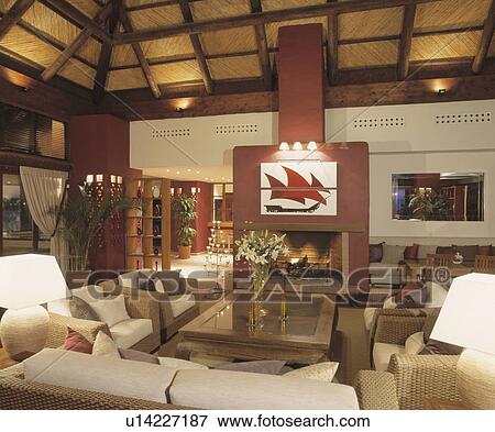 Stock Photo - Wicker sofas in modern Spanish country living room with large fire0place. Fotosearch