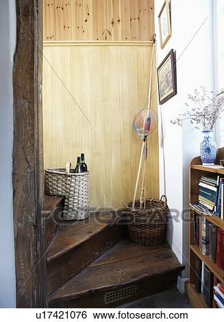 Stock Photograph - Wicker storage basket on old wooden cottage staircase . Fotosearch