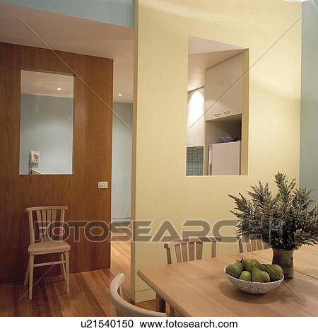 wood dining table in modern dining room with rectangular aperture in cream dividing wall View Large Photo Image Stock Image - wood dining table in modern dining room with rectangular aperture in cream dividing wall. Fotosearch