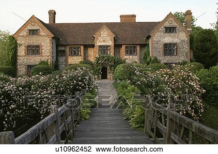 Wooden bridge and pink roses in front of large country house in summer View Large Photo Image Stock Image - Wooden bridge and pink roses in front of large country house in summer. Fotosearch