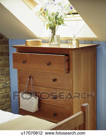 Wooden chest of drawers in a contemporary blue and white bedroom under the eaves of an attic conversion View Large Photo Image Stock Image - Wooden chest of drawers in a contemporary blue and white bedroom under the eaves of an attic conversion. Fotosearch