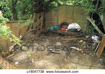 Stock Photo - Wooden fence in small dilapidated town garden before renovation. Fotosearch