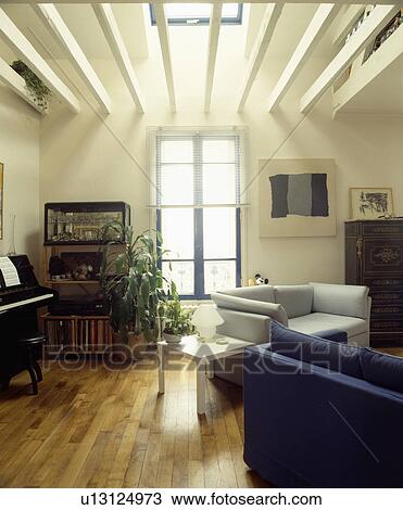 Stock Image - Wooden flooring in modern living room with ceiling beams. Fotosearch