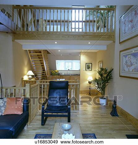 Wooden flooring in modern living room with black leather furniture and mezzanine floor View Large Photo Image Stock Photo - Wooden flooring in modern living room with black leather furniture and mezzanine floor. Fotosearch