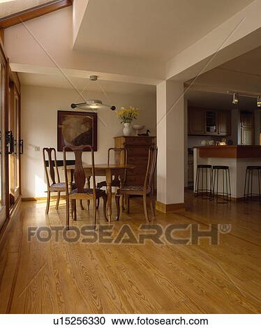 Wooden flooring in openplan kitchen and dining room with traditional furniture below modern disc-light View Large Photo Image Stock Image - Wooden flooring in openplan kitchen and dining room with traditional furniture below modern disc-light. Fotosearch