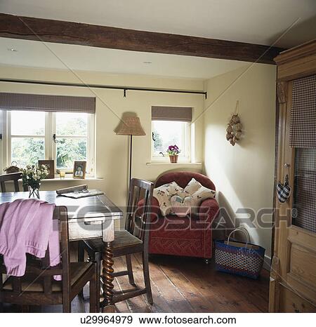 Wooden table and chairs in cottage diningroom with red armchair View Large Photo Image Stock Photo - Wooden table and chairs in cottage diningroom with red armchair. Fotosearch