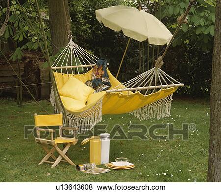 Yellow hammock and chair on lawn in garden in summer View Large Photo Image Stock Photo - Yellow hammock and chair on lawn in garden in summer. Fotosearch
