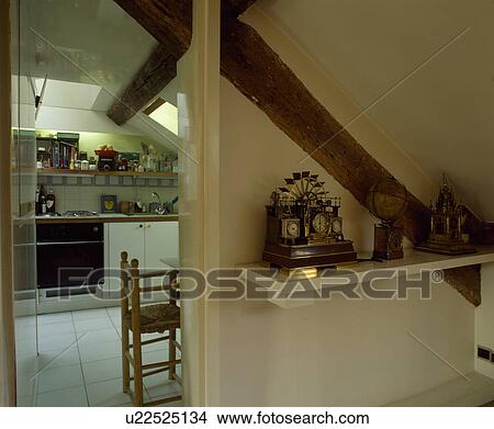 antique clock on shelf beside doorway to modern white attic kitchen View Large Photo Image Picture - antique clock on shelf beside doorway to modern white attic kitchen. Fotosearch