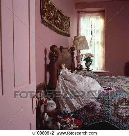Antique doll on bed with patchwork quilt in child's pink cottage bedroom View Large Photo Image Stock Image - Antique doll on bed with patchwork quilt in child's pink cottage bedroom. Fotosearch