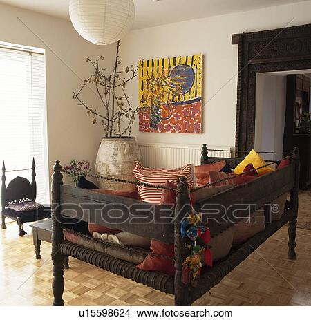 Antique Indonesian day bed and woodblock flooring in modern livingroom with picture above large terracotta pot in the corner of the room View Large Photo Image Picture - Antique Indonesian day bed and woodblock flooring in modern livingroom with picture above large terracotta pot in the corner of the room . Fotosearch