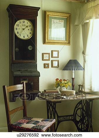 Antique wall clock above old Singer sewingmachine table in corner of cottage study View Large Photo Image Stock Image - Antique wall clock above old Singer sewingmachine table in corner of cottage study. Fotosearch