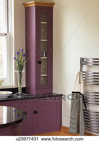 Apron on vertical steel radiator in modern white kitchen with purple fitted cupboards View Large Photo Image Stock Image - Apron on vertical steel radiator in modern white kitchen with purple fitted cupboards. Fotosearch