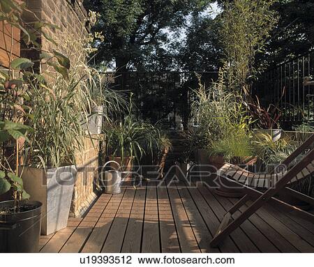 Balcony with deckchair, pots of grasses and watering can. View Large Photo Image Stock Image - Balcony with deckchair, pots of grasses and watering can.. Fotosearch