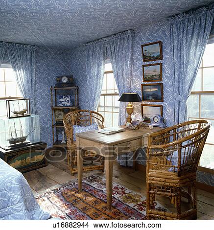 Bamboo chairs and old pine table in bedroom with blue+white Paisley wallpaper and matching curtains on windows View Large Photo Image Picture - Bamboo chairs and old pine table in bedroom with blue+white Paisley wallpaper and matching curtains on windows. Fotosearch