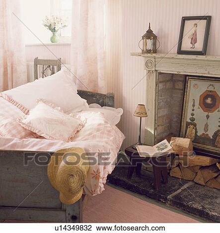 Bedroom with pastel pink pillows and duvet on single bed beside marble fireplace with logs View Large Photo Image Stock Image - Bedroom with pastel pink pillows and duvet on single bed beside marble fireplace with logs. Fotosearch