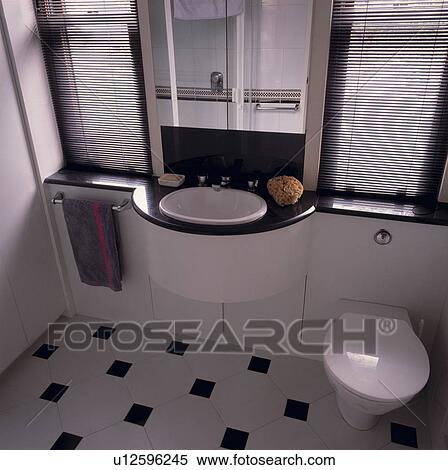 Stock Photography - Black and white architectural bathroom with built in basin and mirror.. Fotosearch