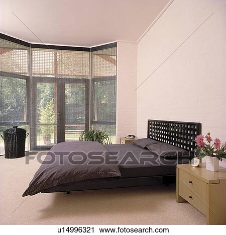 Black duvet and pillows on fretwork bed in modern white bedroom with cream carpet View Large Photo Image Stock Image - Black duvet and pillows on fretwork bed in modern white bedroom with cream carpet. Fotosearch