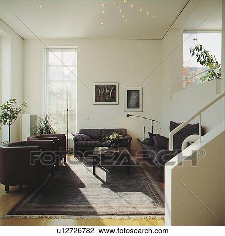Stock Image - Black leather furniture in modern white living room. Fotosearch