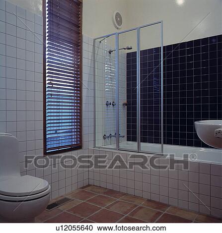 Black slatted blind on narrow window in modern black and whtie bathroom with glass shower panel on bath View Large Photo Image Stock Image - Black slatted blind on narrow window in modern black and whtie bathroom with glass shower panel on bath. Fotosearch