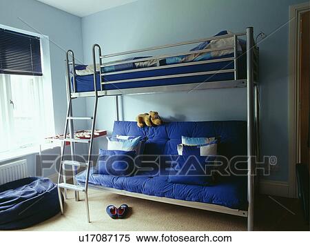Blue futon and cushions below metal platform bed in child's pastel blue bedroom View Large Photo Image Stock Photography - Blue futon and cushions below metal platform bed in child's pastel blue bedroom. Fotosearch