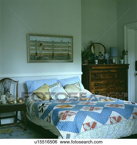 Blue patterned patchwork quilt on bed in traditional bedroom View Large Photo Image Stock Photograph - Blue patterned patchwork quilt on bed in traditional bedroom. Fotosearch