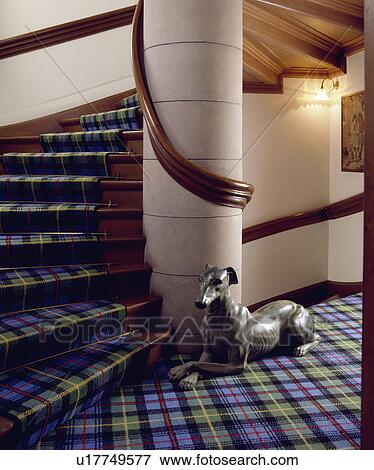 Stock Photo - Blue+green tartan carpet on stairs and landing with statue of dog against stone pillar. Fotosearch