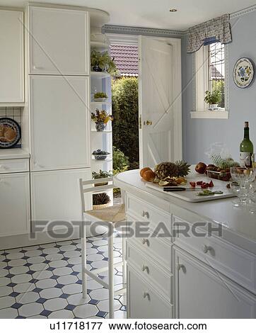 Blue+white ceramic tiled floor in pastel blue kitchen with white fitted cupboards View Large Photo Image Stock Photo - Blue+white ceramic tiled floor in pastel blue kitchen with white fitted cupboards. Fotosearch