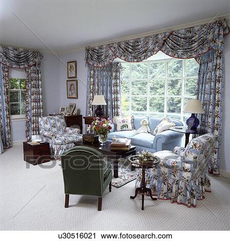 Stock Image - Blue+white curtains and armchairs in traditional living room. Fotosearch