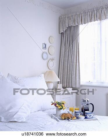 Breakfast tray with cafetiere on bed with white pillows and bedlinen in white bedroom with stencilled border on wall View Large Photo Image Stock Photograph - Breakfast tray with cafetiere on bed with white pillows and bedlinen in white bedroom with stencilled border on wall. Fotosearch