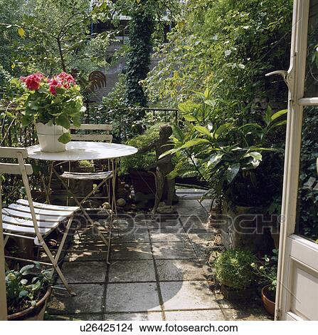Picture - Chairs and table on patio in town garden in summer. Fotosearch