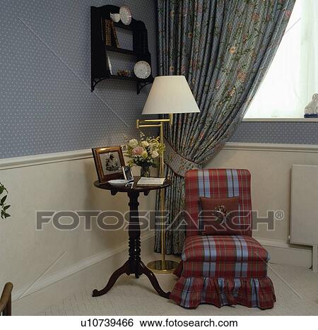 Checked upholstered chair beside table with lamp View Large Photo Image Stock Photograph - Checked upholstered chair beside table with lamp. Fotosearch