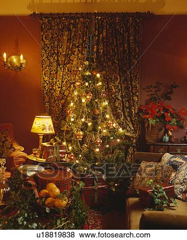 Christmas tree in traditional red living room View Large Photo Image Stock Photo - Christmas tree in traditional red living room. Fotosearch