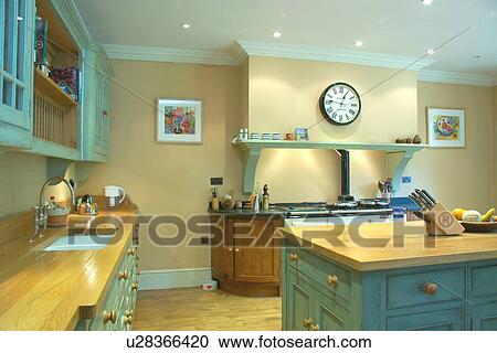 Clock and pastel turquoise shelf above Aga oven in kitchen with turquoise distressed paint effect fitted cupboards View Large Photo Image Stock Image - Clock and pastel turquoise shelf above Aga oven in kitchen with turquoise distressed paint effect fitted cupboards. Fotosearch