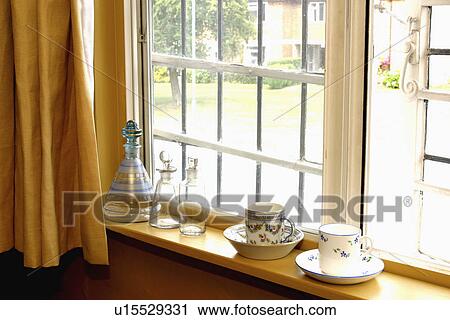 Stock Image - Close-up of antique cups on window sill. Fotosearch