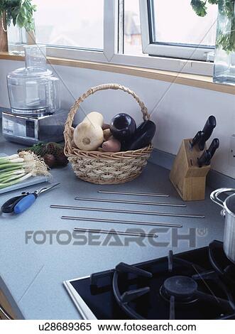 Stock Photography - Close-up of basket of vegetables and knife-rack beside electric mixer on kitchen worktop . Fotosearch