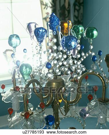 Stock Image - Close-up of chandelier with colourful glass baubles. Fotosearch