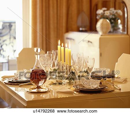 Stock Photo - Close-up of glass decanter and wineglasses on table with lighted candles. Fotosearch