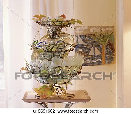 Stock Image - Close-up of glasses in three-tired wirework basket. Fotosearch