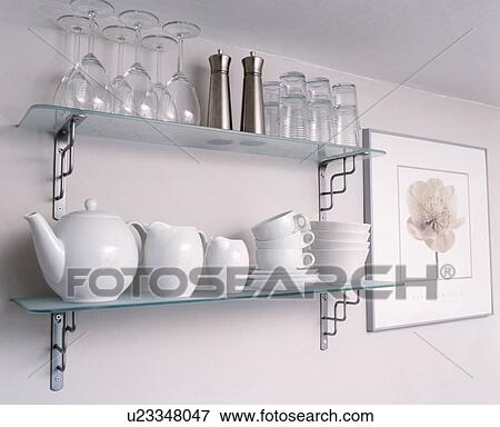 Close-up of glasses with white teapot and matching jugs and cups on glass and steel shelves View Large Photo Image Stock Photo - Close-up of glasses with white teapot and matching jugs and cups on glass and steel shelves. Fotosearch