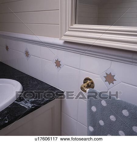 Stock Photo - Close-up of granite-topped bath surround below white tiled wall. Fotosearch