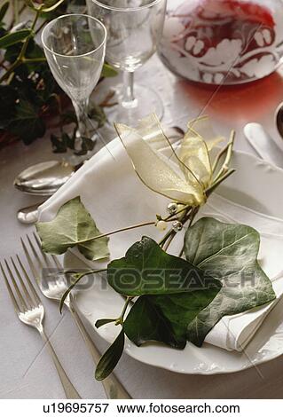 Close-up of green ivy leaves and sprig of mistletoe decorating white plate on Christmas dining table View Large Photo Image Stock Photo - Close-up of green ivy leaves and sprig of mistletoe decorating white plate on Christmas dining table . Fotosearch