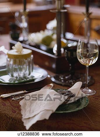 Stock Photograph - Close-up of linen napkin on plate beside glass of white wine. Fotosearch