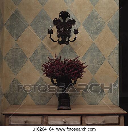 Close-up of metal wall-light on paint effect diamond patterned wall above heather in vase on table View Large Photo Image Picture - Close-up of metal wall-light on paint effect diamond patterned wall above heather in vase on table. Fotosearch