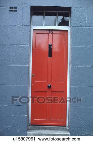 Stock Image - Close up of red front door in blue house. Fotosearch