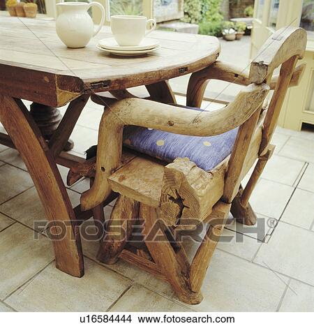 Close-up of rustic wooden chair and table on white tiled floor in dining room View Large Photo Image Picture - Close-up of rustic wooden chair and table on white tiled floor in dining room. Fotosearch