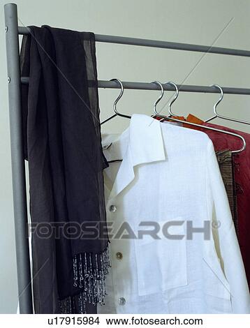Picture - Close-up of scarf and shirts on metal clothes rail. Fotosearch