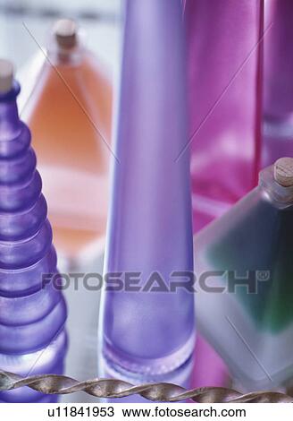 Stock Image - Close-up of spiral and conical purple glass bottles. Fotosearch