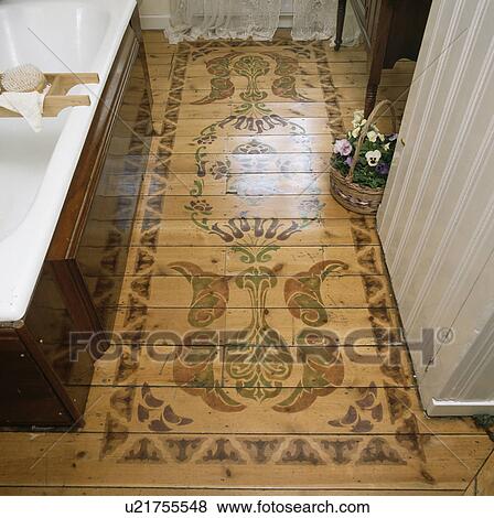 Stock Photo - Close-up of stencilled wooden floorboards in traditional bathroom. Fotosearch