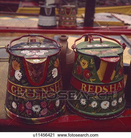 Stock Image - Close up of traditional floral decorated water cans on narrow boat. Fotosearch